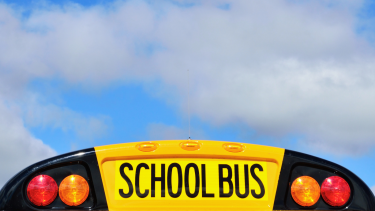 School Bus Registration Back of a school bus with cloudy blue sky in background