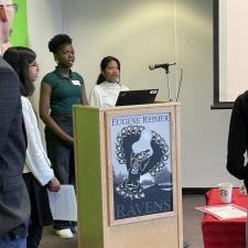 2 female students stand at podium to make a speech 